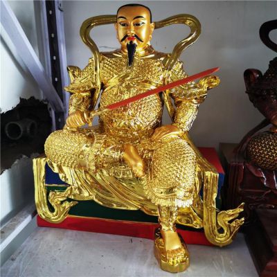 金色鎏金真武大帝銅像，單手持劍一腳盤坐一腳著地的真武祖師塑像